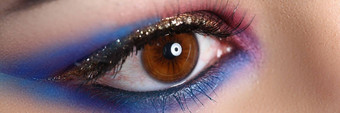 特写镜头棕色（的）女眼睛美丽的棕色（的）红色的橙色调烟雾缭绕的眼睛化妆