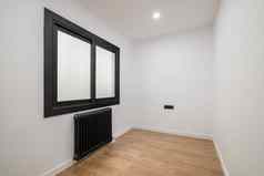 空房间现代版本塑料窗口黑色的框架不透明的玻璃散热器加热黑色的明亮的照明天花板木木条镶花之地板