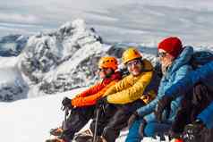 集团登山者坐着太阳前雪山