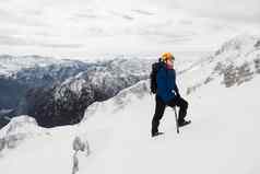 徒步旅行者穿保护头盔太阳镜徒步旅行雪山