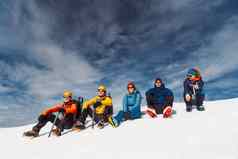 集团登山者坐着太阳高雪阿尔卑斯山脉