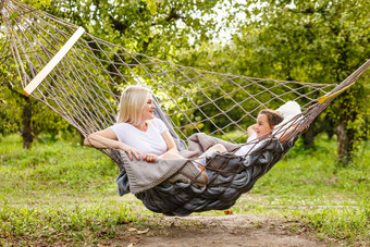 爱的家庭花时间夏天时间享受的事情慢生活妈妈女儿放松吊床夏天花园