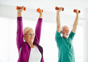 高级伸展运动锻炼女人培训生活方式体育运动健身首页健康的健身房锻炼适合男人。夫妇团队哑铃提升强度提升weigth