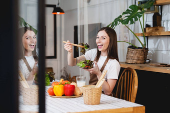 年轻的健康的女人烹饪健康的食物厨房首页健康的生活方式食物饮食概念