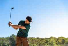 年轻的男人。玩高尔夫球夏天生活方式游戏健康的运动在户外浓度技能概念