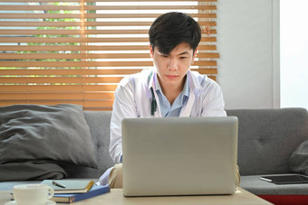 集中医生白色外套坐着办公室看在线医疗网络研讨会研讨会培训移动PC电脑