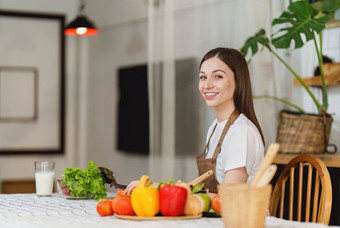 年轻的健康的女人烹饪健康的食物厨房首页健康的生活方式食物饮食概念