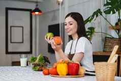 年轻的健康的女人烹饪健康的食物厨房首页健康的生活方式食物饮食概念