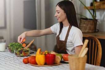 年轻的健康的女人烹饪健康的食物厨房首页健康的生活方式食物饮食概念