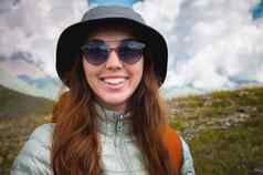 快乐的旅游太阳镜站肖像旅行者山快乐女人帽享受阳光徒步旅行山旅游眼镜