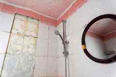 脏破旧的浴室下降瓷砖架子上淋浴站