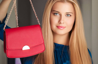 时尚配件快乐美丽的女人持有小红色的手提包金细节时尚的附件奢侈品购物