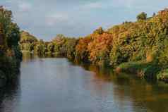 秋天景观彩色的树河美丽的风景如画的背景自然油漆美丽的视图河秋天树海岸天空山景观湖秋天树色彩斑斓的树叶海岸美丽的自然风景阳光明媚的一天毛茸茸的云蓝色的天空反映波及水表面