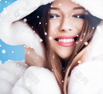 快乐<strong>假期</strong>美冬天时尚美丽的女人穿白色毛茸茸的皮毛外套下雪雪蓝色的背景圣诞节一年<strong>假期生活</strong>方式肖像