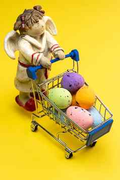 困了天使携带色彩斑斓的复活节鸡蛋购物篮子