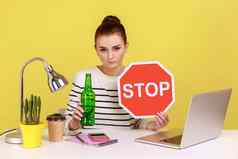 女人显示含酒精的饮料啤酒瓶停止标志坐着工作场所移动PC