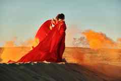 女人红色的衣服跳舞沙漠