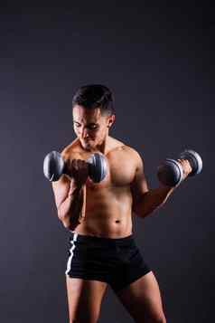 肖像年轻的健身运动强大的男人。bare-chested肌肉发达的运动员孤立的灰色黑暗