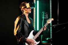 女人音乐家玩电吉他声音工作室穿虚拟现实耳机音乐会模拟