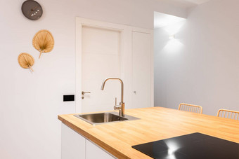 特写镜头厨房岛木表格前单蜂蜜颜色调色板工作台面内置的水槽陶瓷板排气系统位于