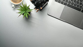 白色工作桌子上移动PC电脑盆栽植物铅笔持有人咖啡杯前视图复制空间