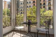 铁椅子表格关闭上釉阳台美丽的视图舒适的区域温暖的国家阳光明媚的夏天一天概念浪漫的酒店房间度蜜月的
