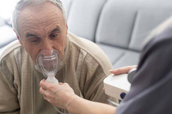 上了年纪的高级男人。护理护理穿氧气吸入器设备帮助<strong>呼吸呼吸</strong>氧气集中器可移植的