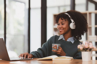 年轻的黑色的非洲女人穿耳机享受音乐音乐应用程序移动电话
