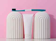 白色塑料牙膏管牙刷粉红色的背景
