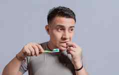 年轻的男人。牙龈炎持有牙刷人持有牙刷口香糖疼痛男人。持有牙刷口香糖疼痛人持有牙刷口香糖问题孤立的