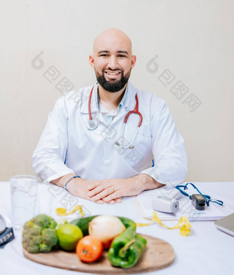 微笑营养学家医生桌子上移动PC蔬菜有胡子的营养学家医生工作场所肖像微笑营养学家桌子上