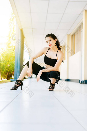 跳舞艺术家女人高高跟鞋在户外肖像跳舞女孩高高跟鞋蹲地板上肖像舞者女人高跟鞋地板上相机