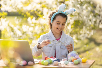 快乐青少年女孩穿<strong>兔子耳朵</strong>油漆复活节鸡蛋移动PC花园