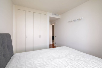现代明亮的卧室床上内置的衣柜开放通过走廊简约舒适的设计概念酒店租赁公寓设计