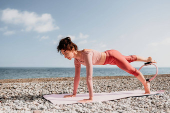 女人海普拉提<strong>运动快乐</strong>中间岁的女人练习健身海滩海微笑活跃的女培训环瑜伽席<strong>享</strong>受健康的生活方式和谐冥想