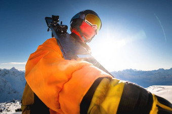 肖像滑雪背景白雪覆盖的山高加索地区男人。滑雪面具滑雪头盔肩膀持有滑雪板山滑雪度假胜地概念