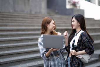 快乐的亚洲大学女<strong>学生会</strong>说话的分享的想法工作学校项目