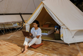 年轻的亚洲女人自由职业者工作在线移动PC前面帐篷山