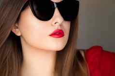 美时尚风格脸肖像美丽的女人穿时尚的猫眼睛太阳镜红色的口红化妆奢侈品附件夏天生活方式魅力别致的