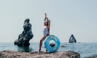 女人夏天海快乐女人游泳充气甜甜圈海滩夏天阳光明媚的一天包围火山山夏天假期概念