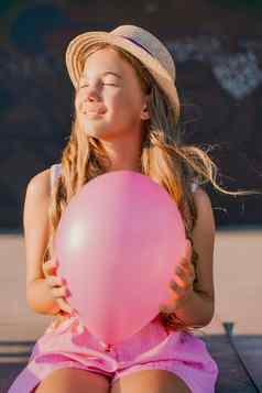 肖像女孩他粉红色的气球穿着粉红色的衣服头发长宽松的