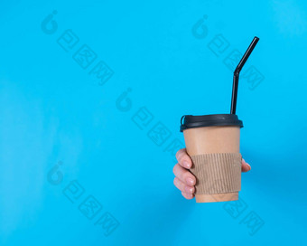 女人持有纸板杯咖啡女人的手棒洞蓝色的背景