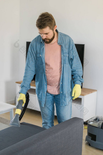 男人。干洗衣店员工手保护橡胶手套清洁沙发专业提取方法早期春天常规的清理商业清洁公司概念