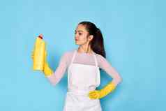 女人手套更清洁的围裙持有瓶洗涤剂