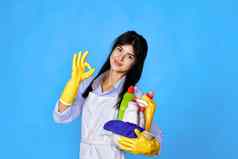 女人手套持有桶洗涤剂显示手势