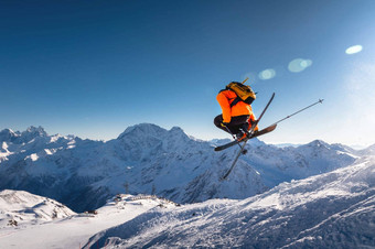 滑雪跳跃背景蓝色的天空白雪覆盖的山<strong>自由泳</strong>滑雪执行直升机交叉滑雪板同时完整的旋转