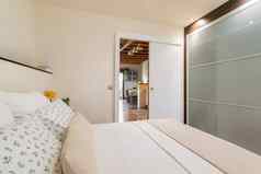 舒适的小卧室白色音调双床上玻璃衣柜架子上开放通过俯瞰厨房概念舒适的住房小家庭