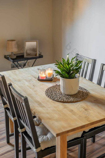 前视图木餐厅表格椅子装饰元素植物蜡烛枕头光墙背景概念时尚的室内自然材料装饰