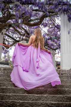 女人紫藤紫色的衣服深思熟虑的快乐成熟的女人紫色的衣服包围中国人紫藤