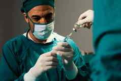 外科医生填满注射器瓶外科手术过程无菌操作房间